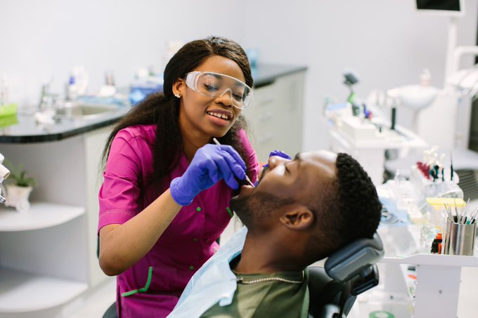 Dental hygienist cleaning patient's mouth